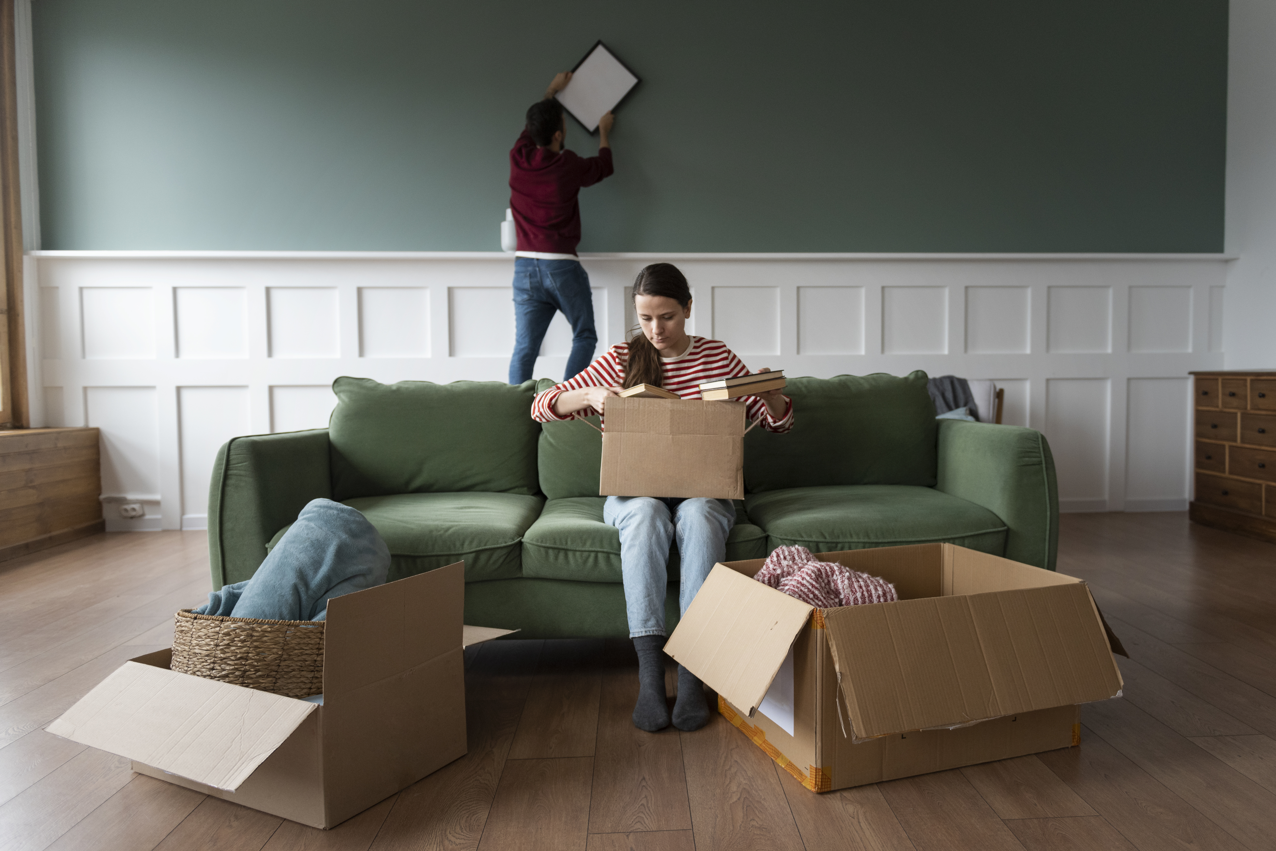 Two people unpacking boxes in a home