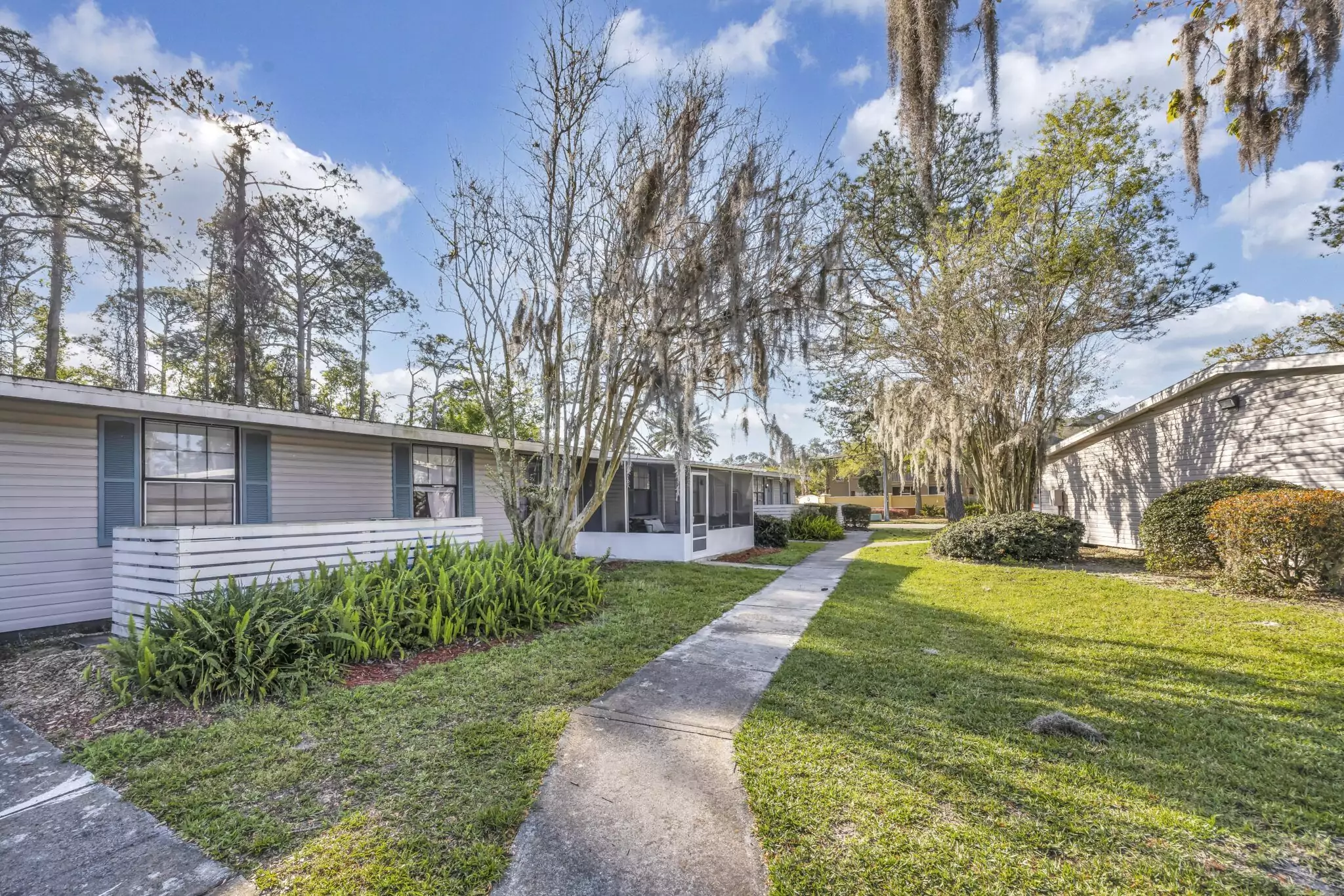Single-story JaxBay apartment homes along a landscaped walkway in Jacksonville